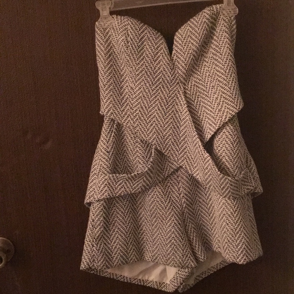 Black and white knitted romper with pockets.